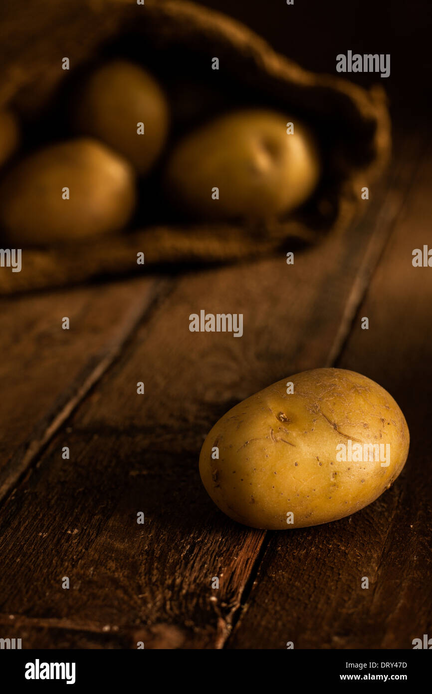 Kartoffeln mit Jute Sack auf Holz Stockfoto