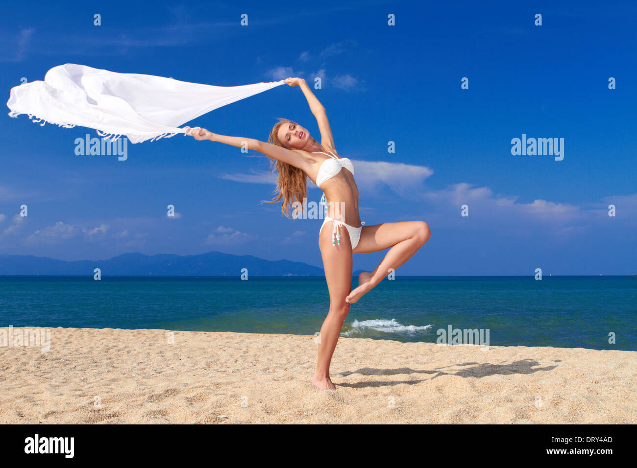 Bikini bekleideten Schönheit in einer Tänzer Pose am Strand Stockfoto