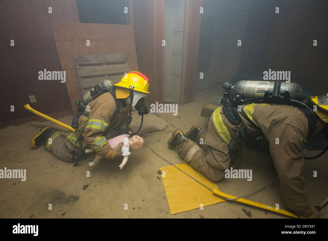 Feuer-Akademie Gymnasiasten kriechen durch verrauchten Haus nach Rettung gefangen 'Baby' während Übung Stockfoto