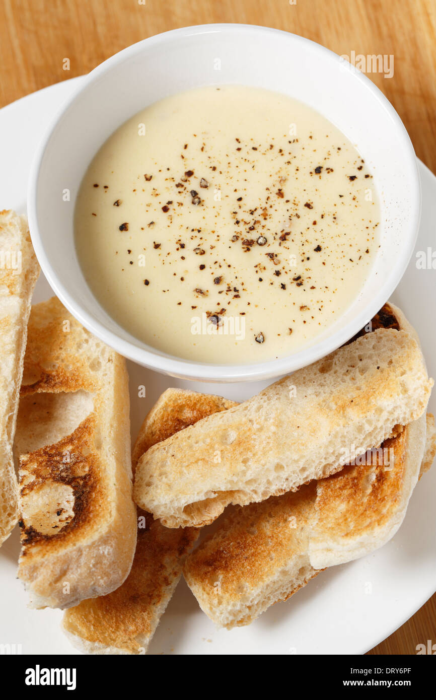 Käse-Dip mit Frischkäse, Milch, Ei und Butter in einer Bain Marie, mit Pfeffer bestreut mit Ciabata Crostini serviert gemacht. Stockfoto