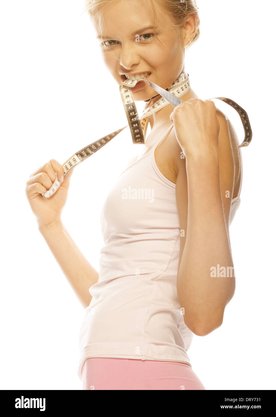 Junge Frau mit Maßband um Hals und zwischen den Zähnen Stockfoto