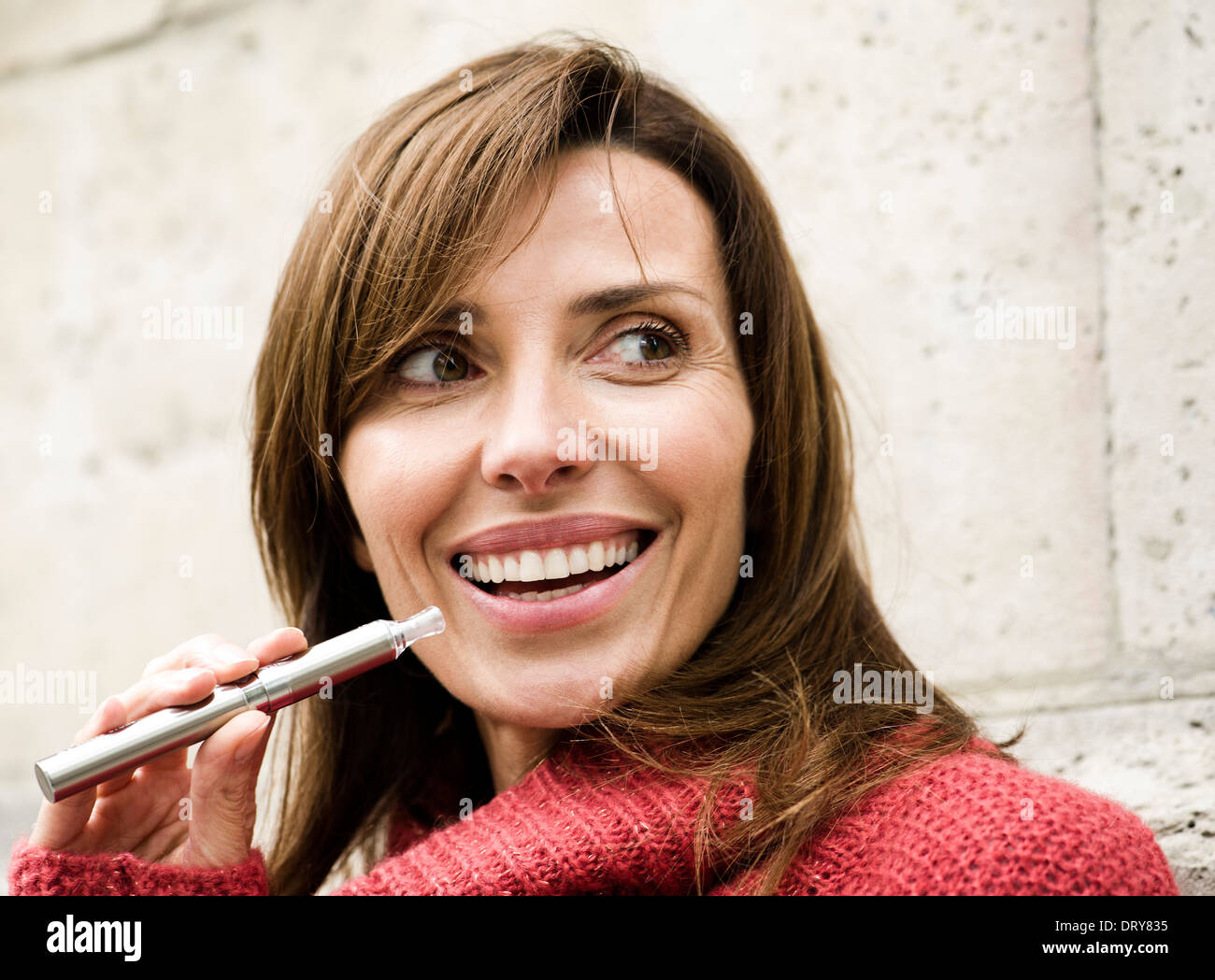 Frau rauchen elektronische Zigarette, Lächeln Stockfoto