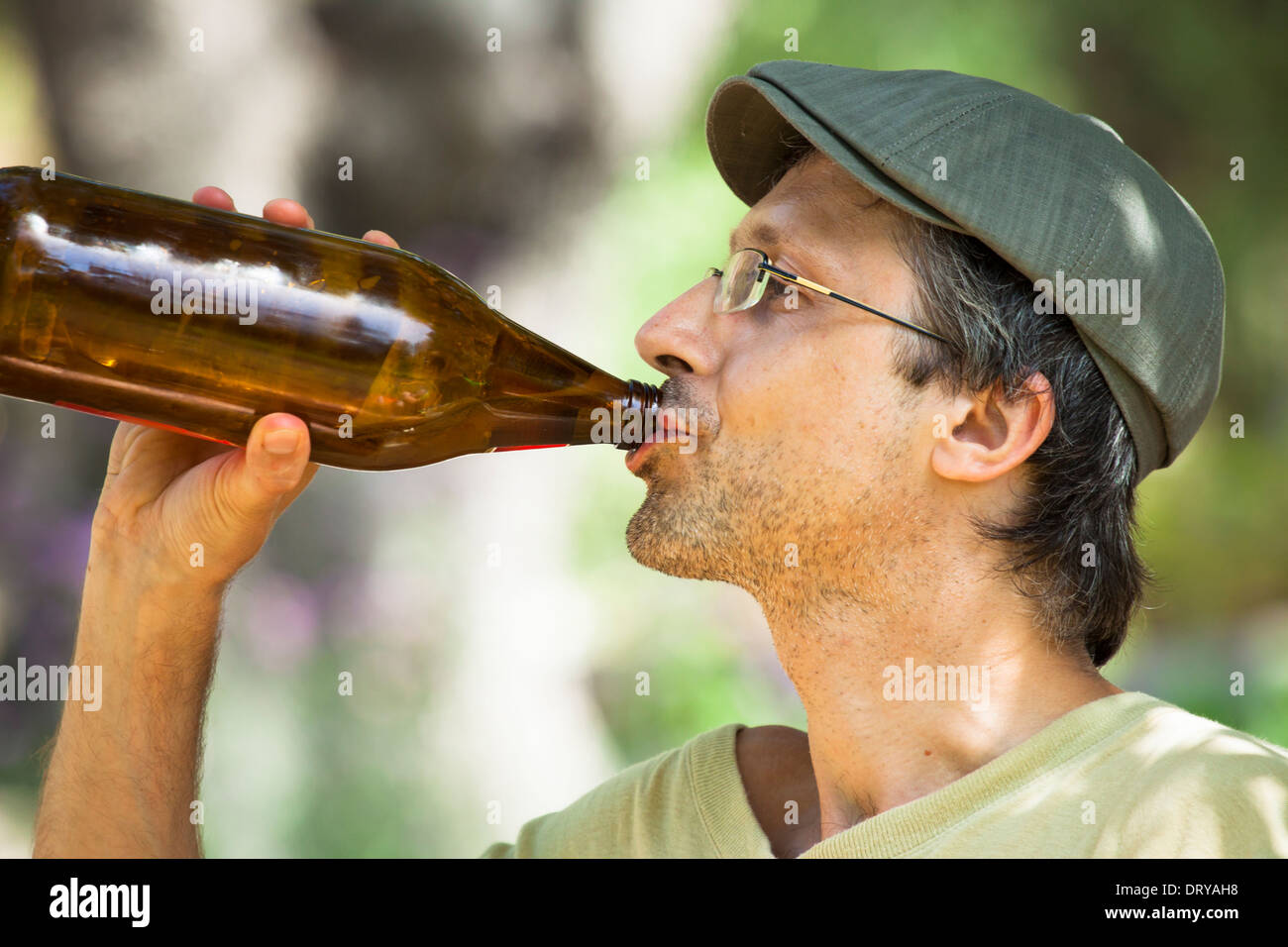 Nahaufnahme eines Mannes trinken Bier aus der Flasche im Freien. Stockfoto