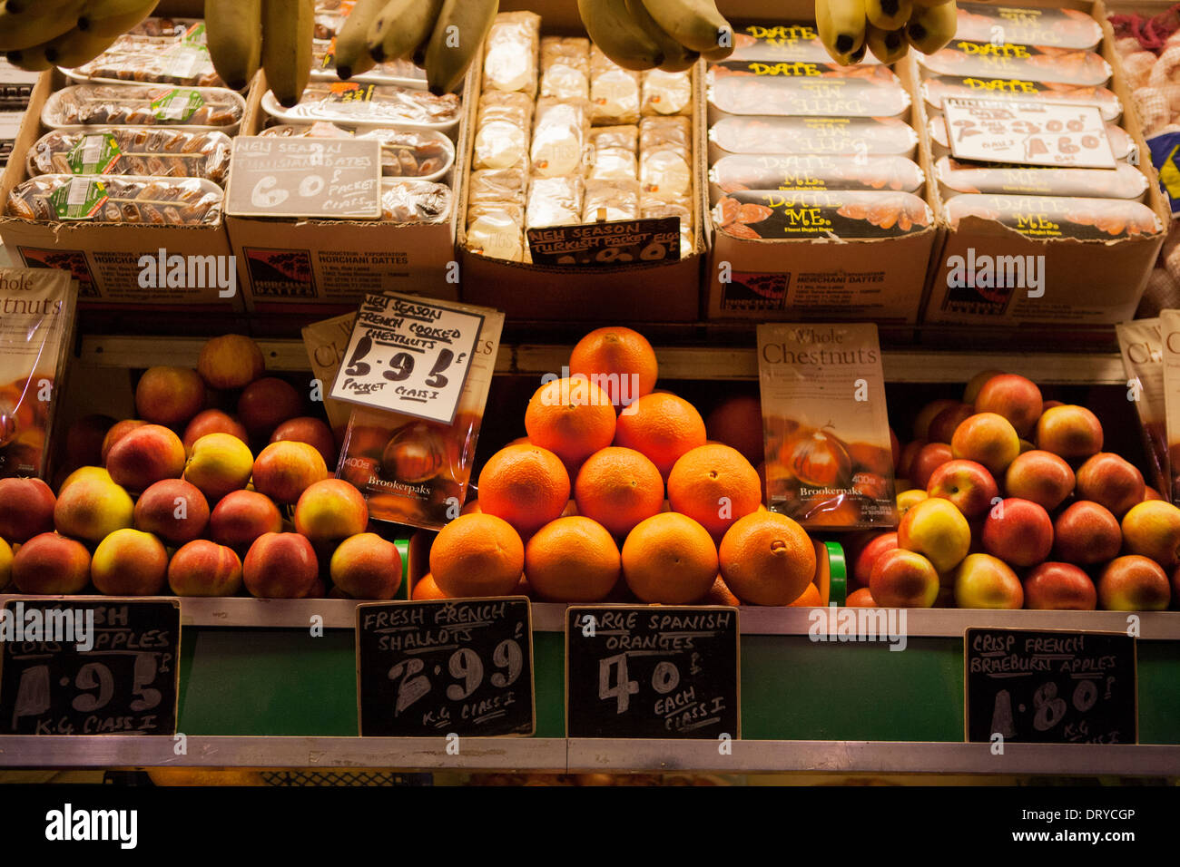 Eine dreieckige Darstellung der Orangen und Äpfel auf einem Marktstand grüne Lebensmittelhändler. Stockfoto