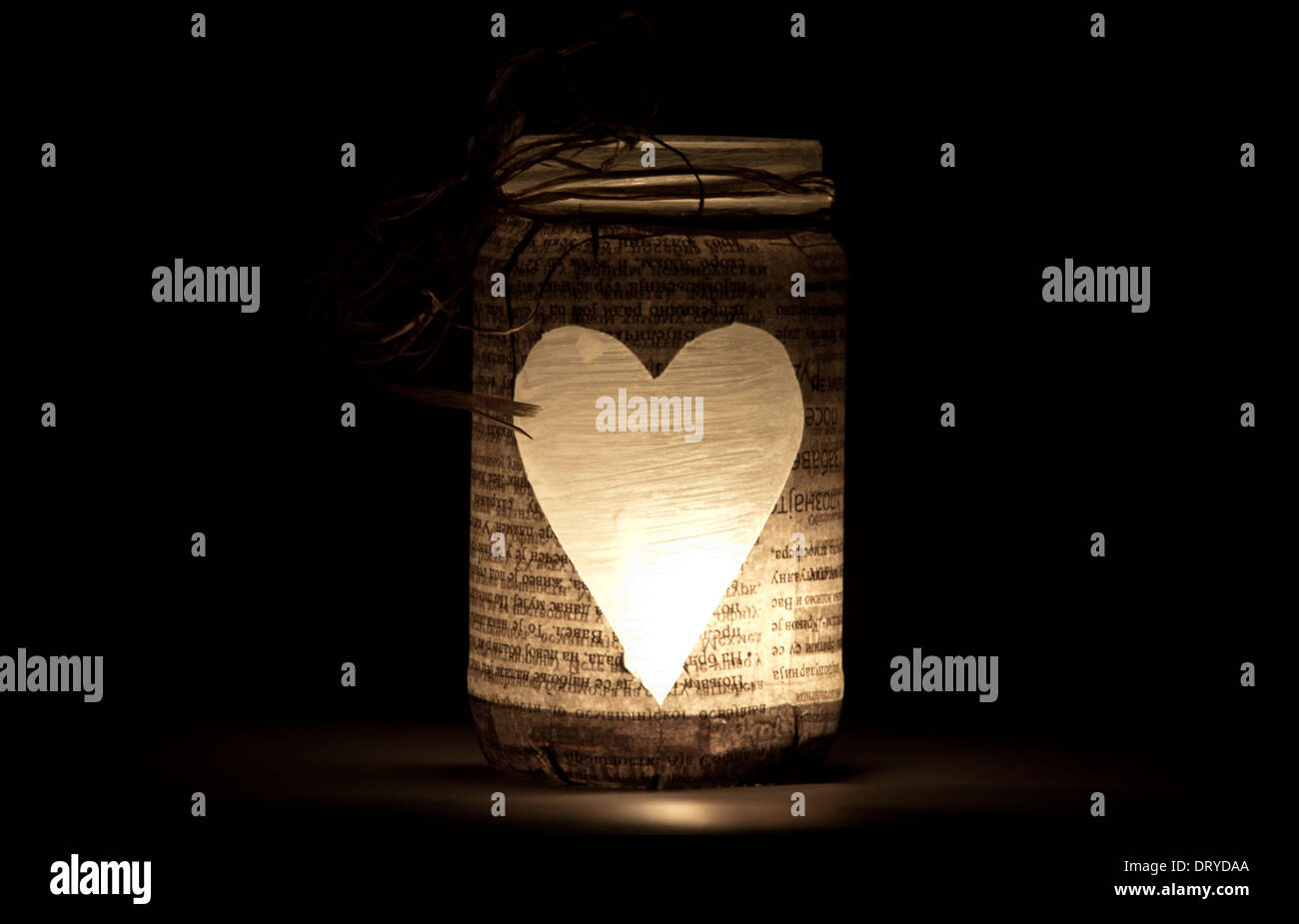 Kerzenhalter, hergestellt aus einem leeren Glas, alte Zeitung und etwas Kleber. Stockfoto