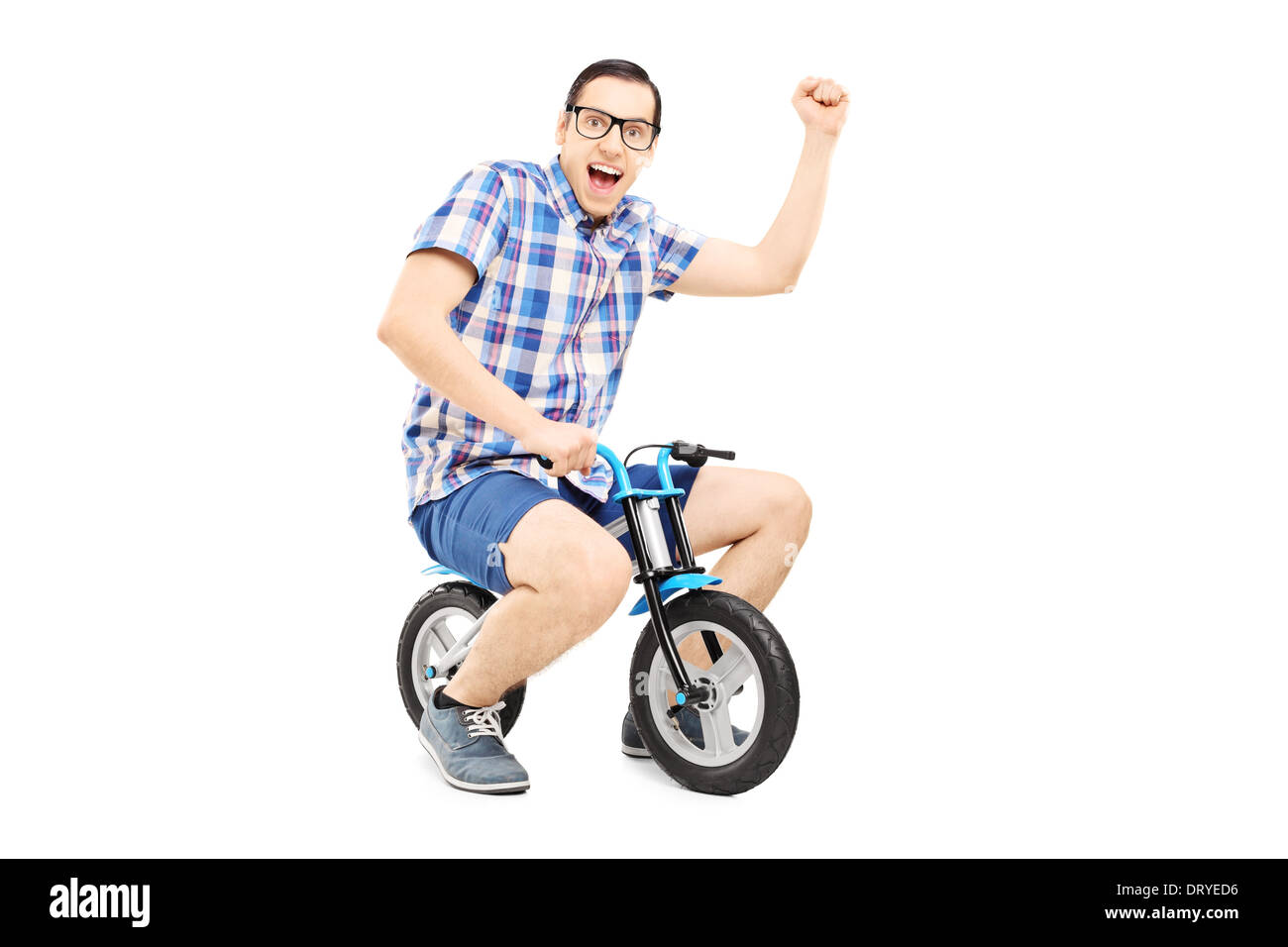 Junger Mann mit erhobener Faust mit dem kleinen Fahrrad Stockfoto