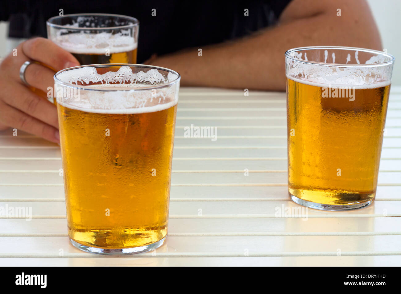 Nahaufnahme von Gläser frisches Bier und die Hände auf den Tisch. Stockfoto