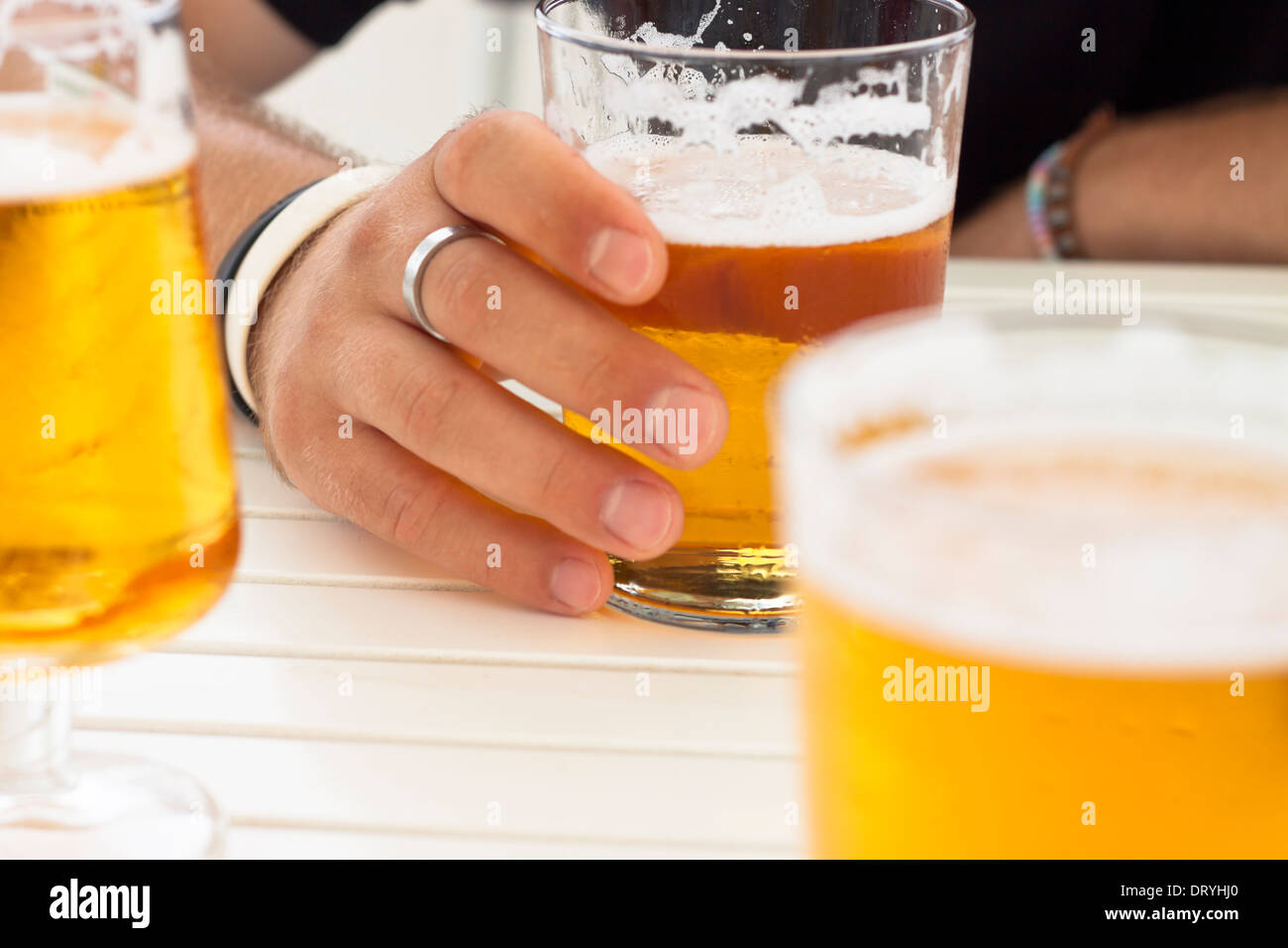 Nahaufnahme von Gläser frisches Bier und männliche Hand am Tisch. Stockfoto