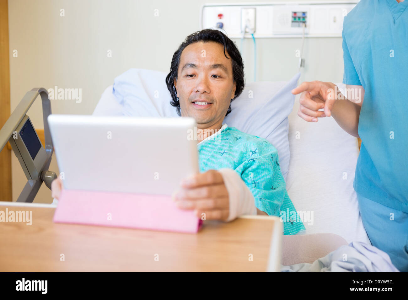 Krankenschwester auf Digital-Tablette während Patienten unter Verwendung es Stockfoto