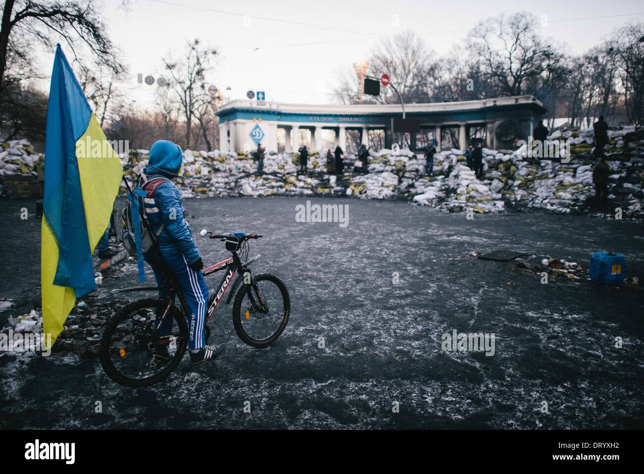 Kiew, Ukraine. 4. Februar 2014. Junge mit Fahne am Fahrrad in der Nähe von Barrikaden. Die Front ist mit Schnee bedeckt, wie die angespannte Pattsituation auf Hrushevskoho Straße in der Nähe von Dynamo-Stadion weiter. Ukrainischen Parlaments verabschiedet härtere Gesetze gegen öffentliche Demonstrationen. Bildnachweis: Jacob Balzani Loov/ZUMA Wire/ZUMAPRESS.com/Alamy Live-Nachrichten Stockfoto