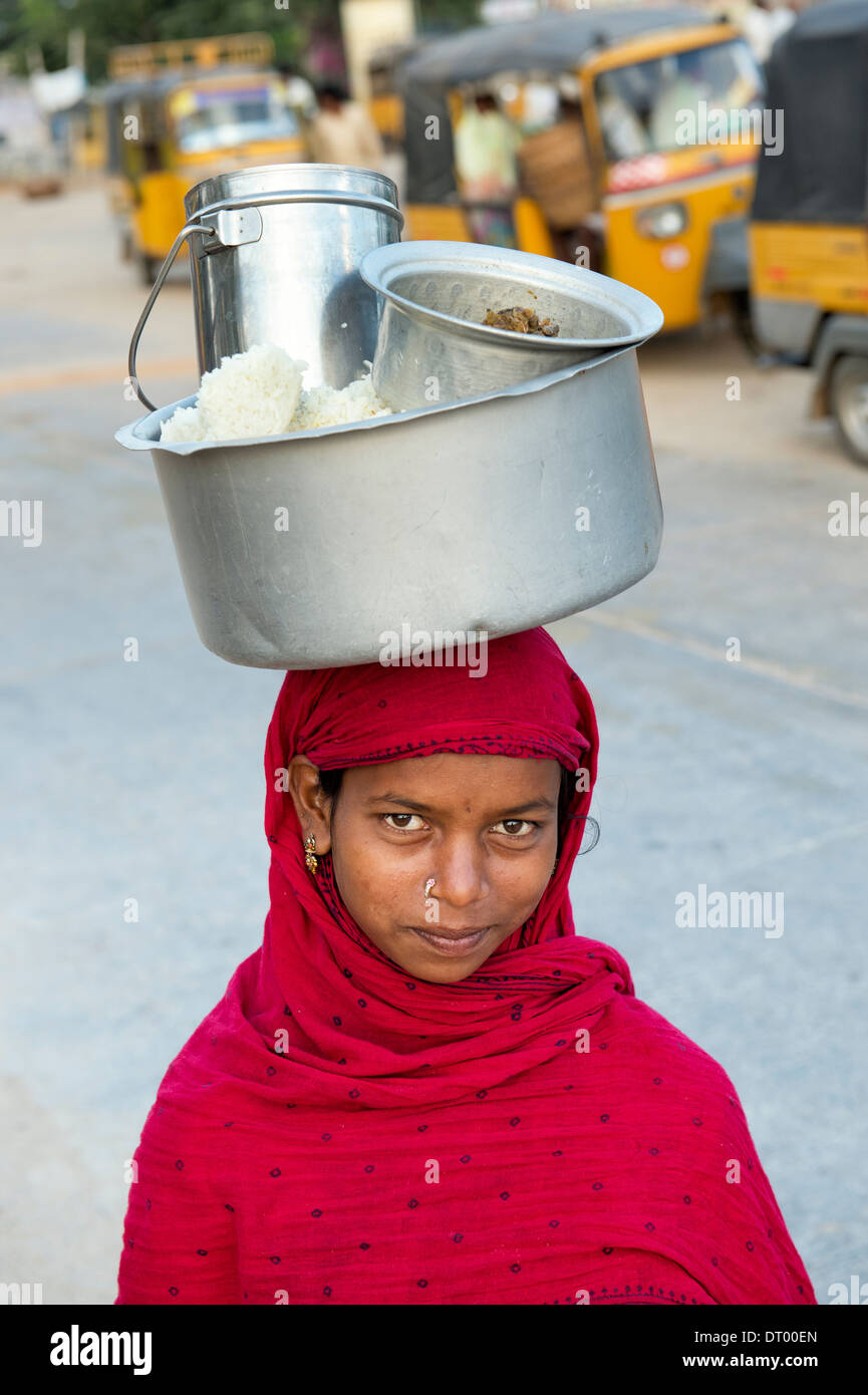 Armen niedrigere Kaste indischen Teenager-Mädchen mit einem Topf Reis auf dem Kopf. Andhra Pradesh, Indien Stockfoto