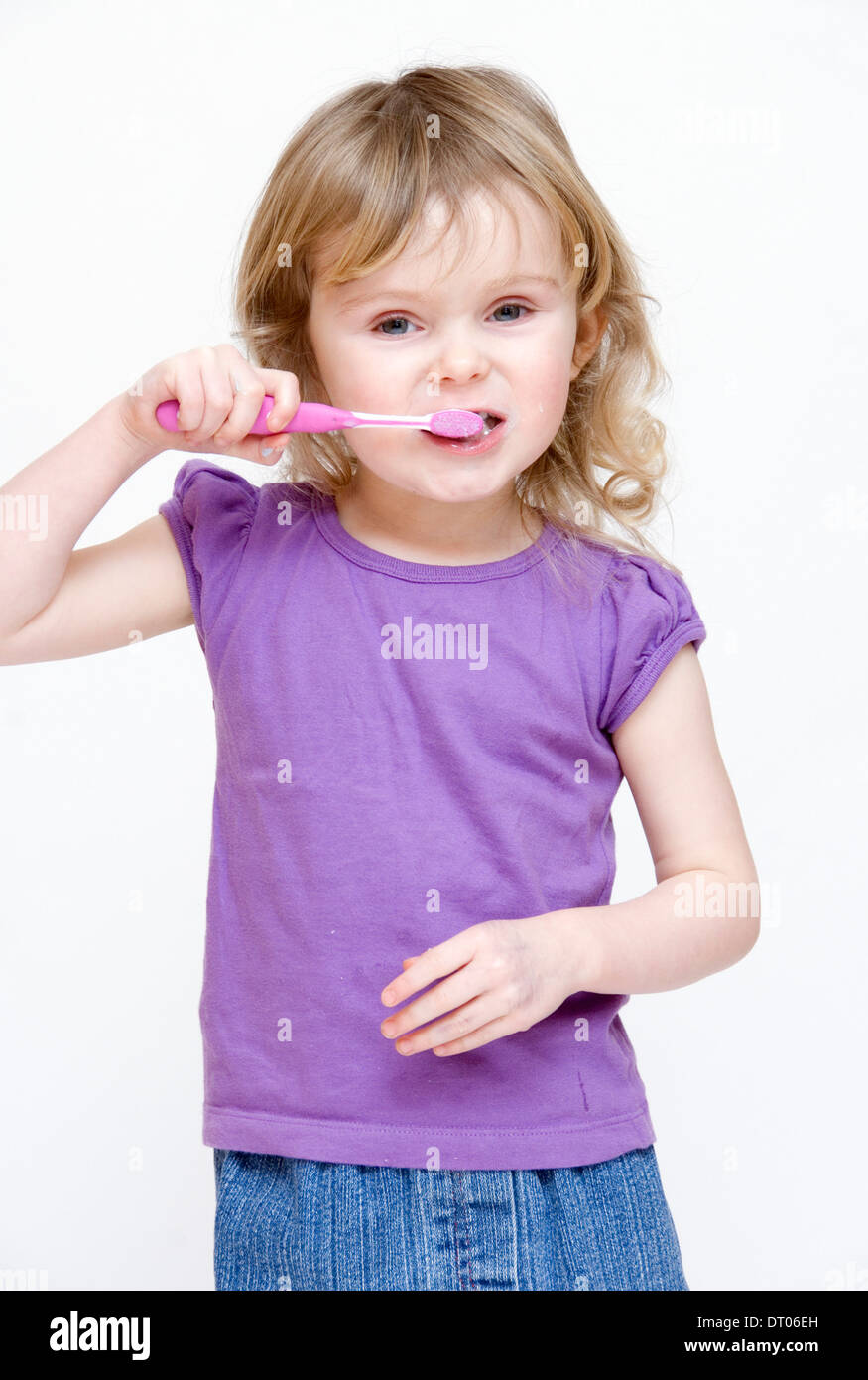 Niedliche kleine Mädchen ihre Zähneputzen, isoliert auf weiss Stockfoto
