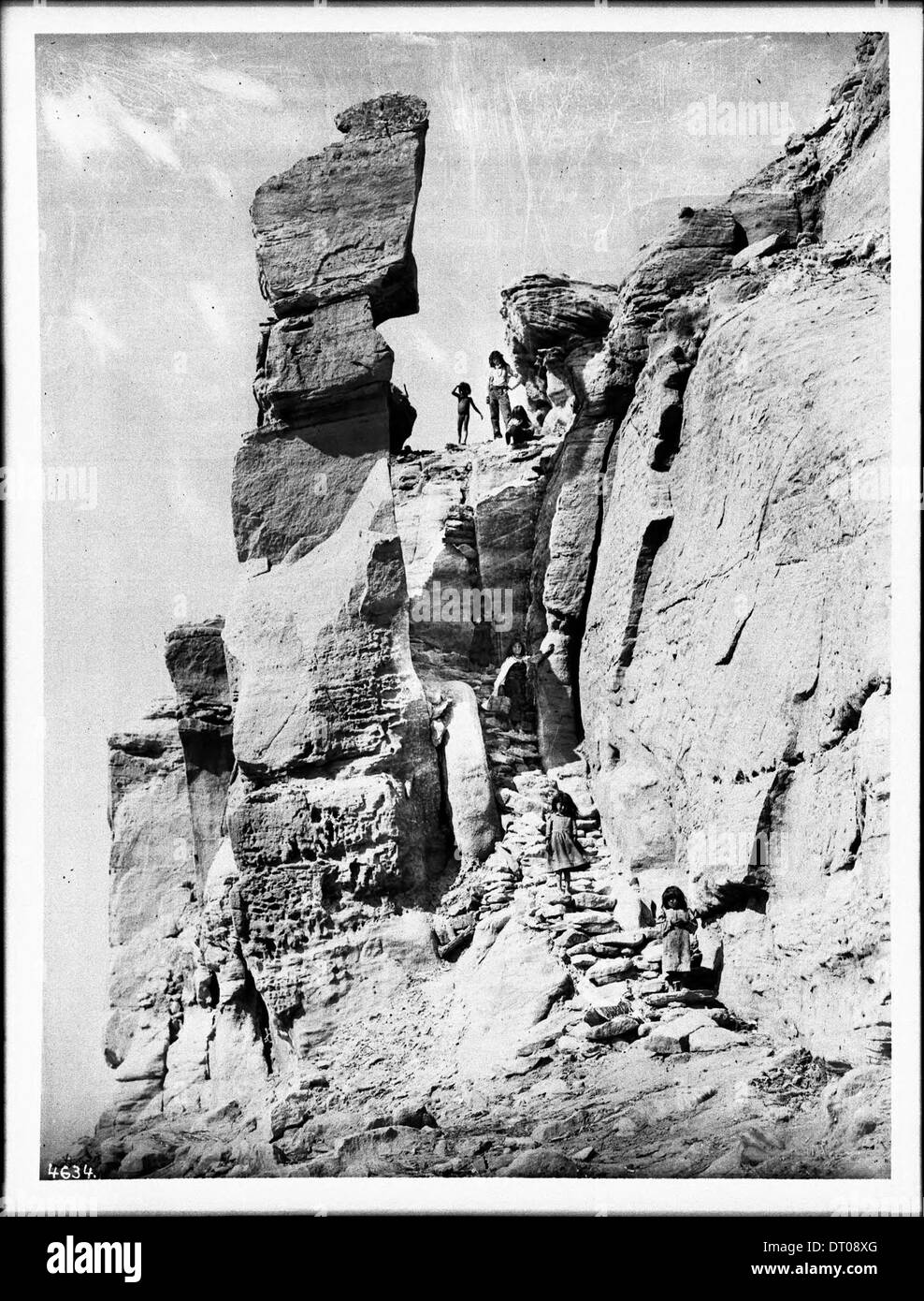 Eine Gruppe von Kindern wird auf den Stufen des südöstlichen Weges zum Hopi Pueblo von Walpi auf der First Mesa, Arizona, um 1898 gesehen, die einen Einblick in das Leben der Hopi zeigen. Stockfoto