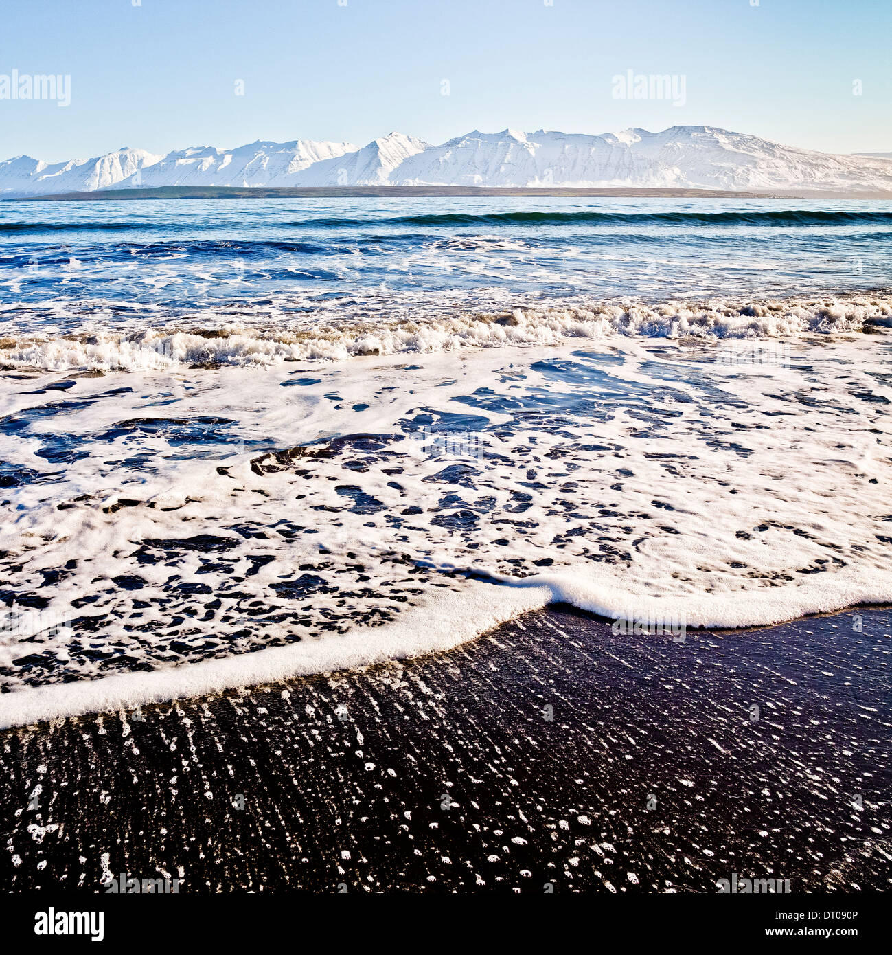 Wellen brechen sich am schwarzen Sandstrand, Dalvik, Island Stockfoto