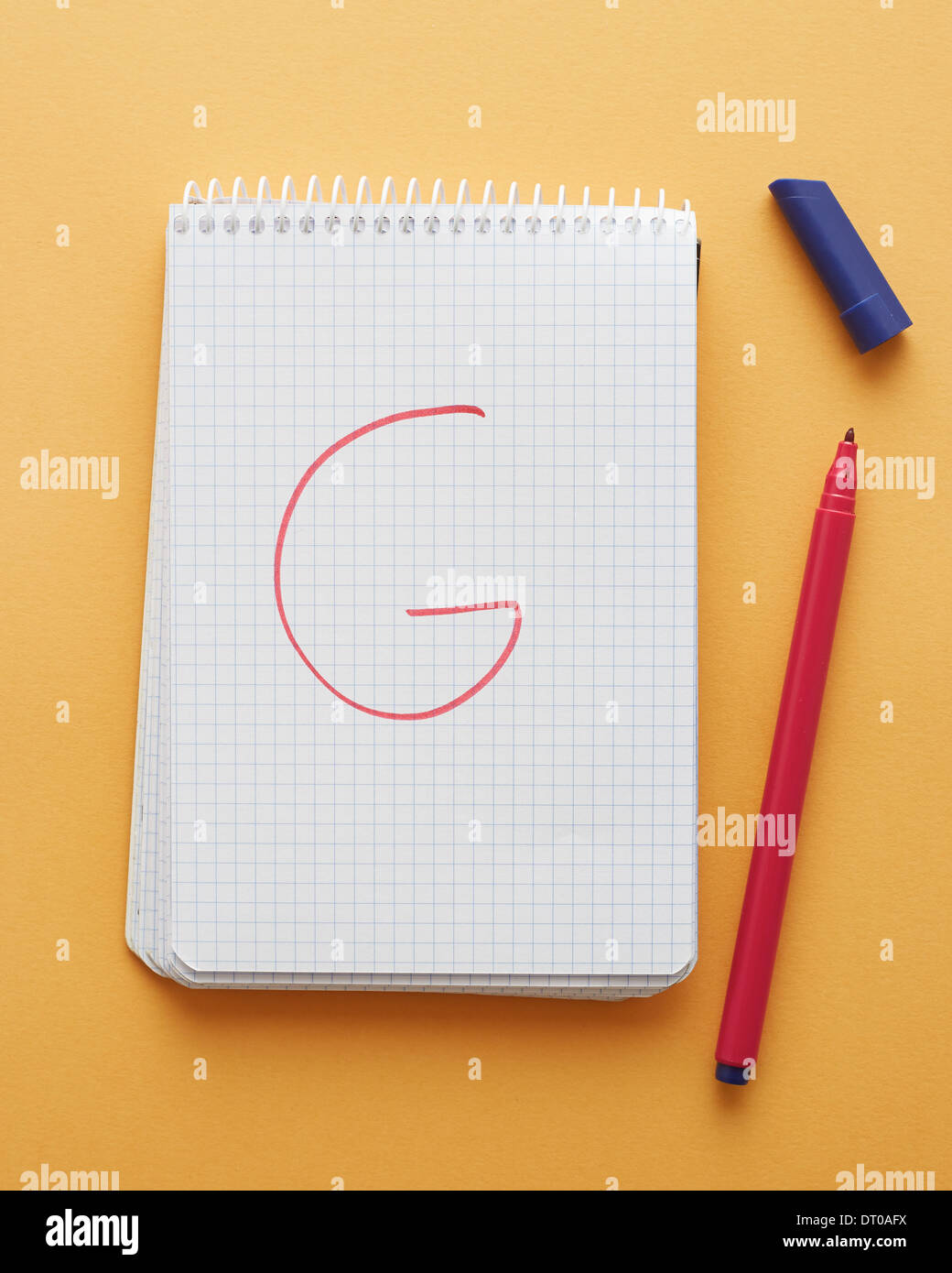 G-Brief handschriftlich in Notizblockseite auf gelbem Hintergrund alphabet Stockfoto