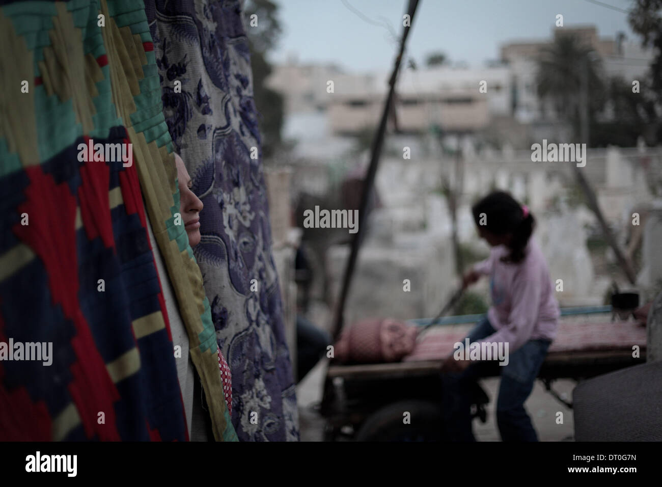Gaza, Palästinensische Gebiete. 5. Februar 2014. Eine Frau schaut auf ihre Kinder, die spielen auf dem Friedhof im Friedhof Zaytoon in Gaza-Stadt. Bildnachweis: Ahmed Deeb/NurPhoto/ZUMAPRESS.com/Alamy Live-Nachrichten Stockfoto