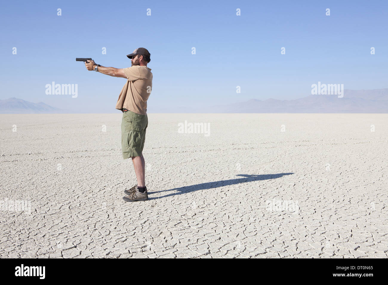 Black Rock Wüste Nevada USA Mann, mit dem Ziel Handfeuerwaffe mit seinem ausgestreckten arm Stockfoto