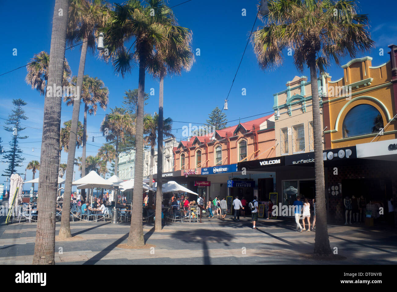 Der Corso Manly Sydney New South Wales NSW Australia Pelm Bäume Passanten Menschen an Café-Tischen Stockfoto