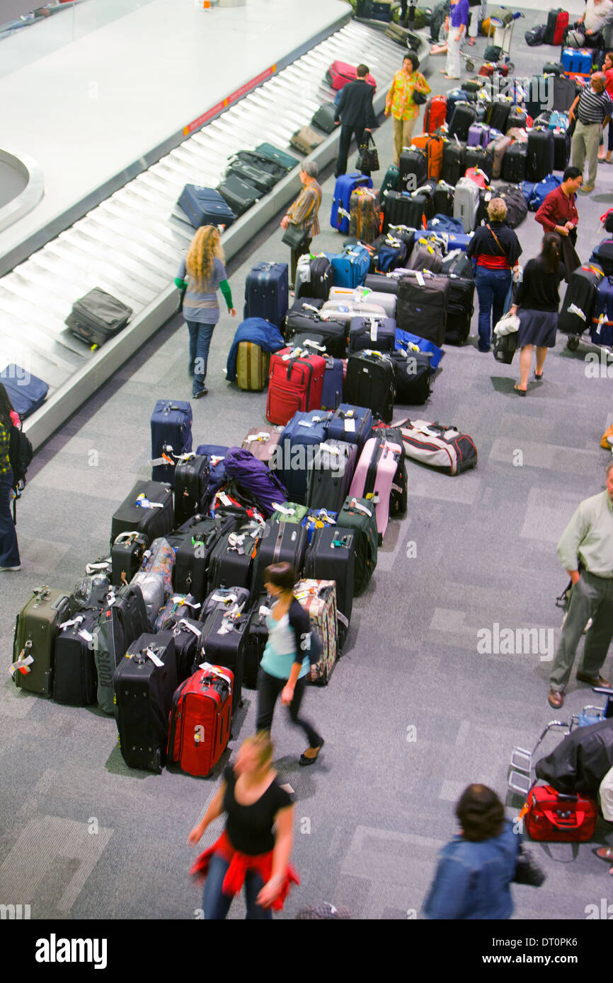 Reisende warten auf einem Flughafen auf dem Gepäckband. Stockfoto
