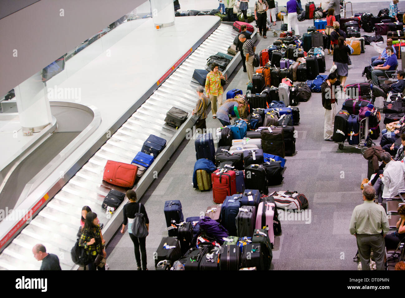 Reisende warten auf einem Flughafen auf dem Gepäckband. Stockfoto
