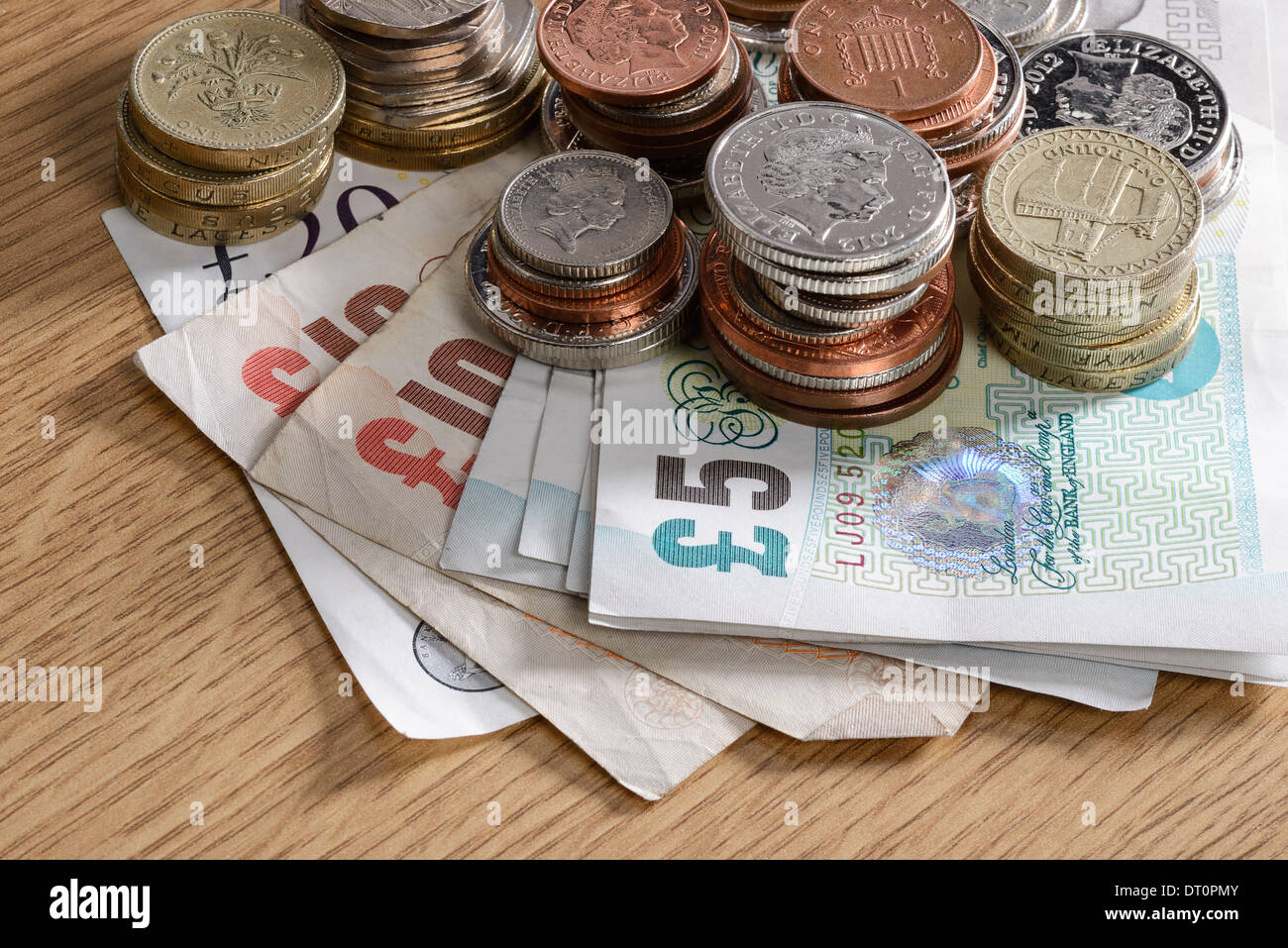 Haufen von UK Sterling Bargeld Banknoten und Münzen Stockfoto