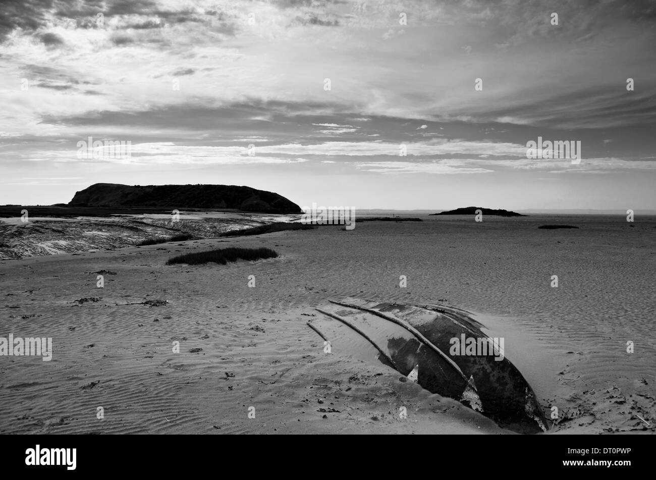 Umgedrehten Boot vergraben im Sand am Strand mit Hügeln in der Ferne Stockfoto