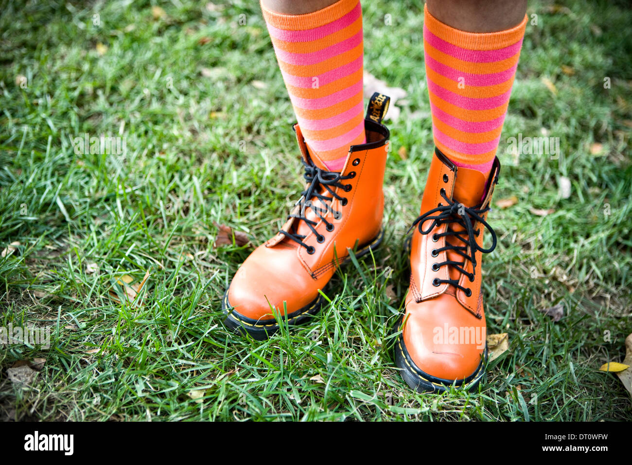 Nahaufnahme der Beine mit orange Stiefel und Gestreifte Kniestrümpfe Stockfoto
