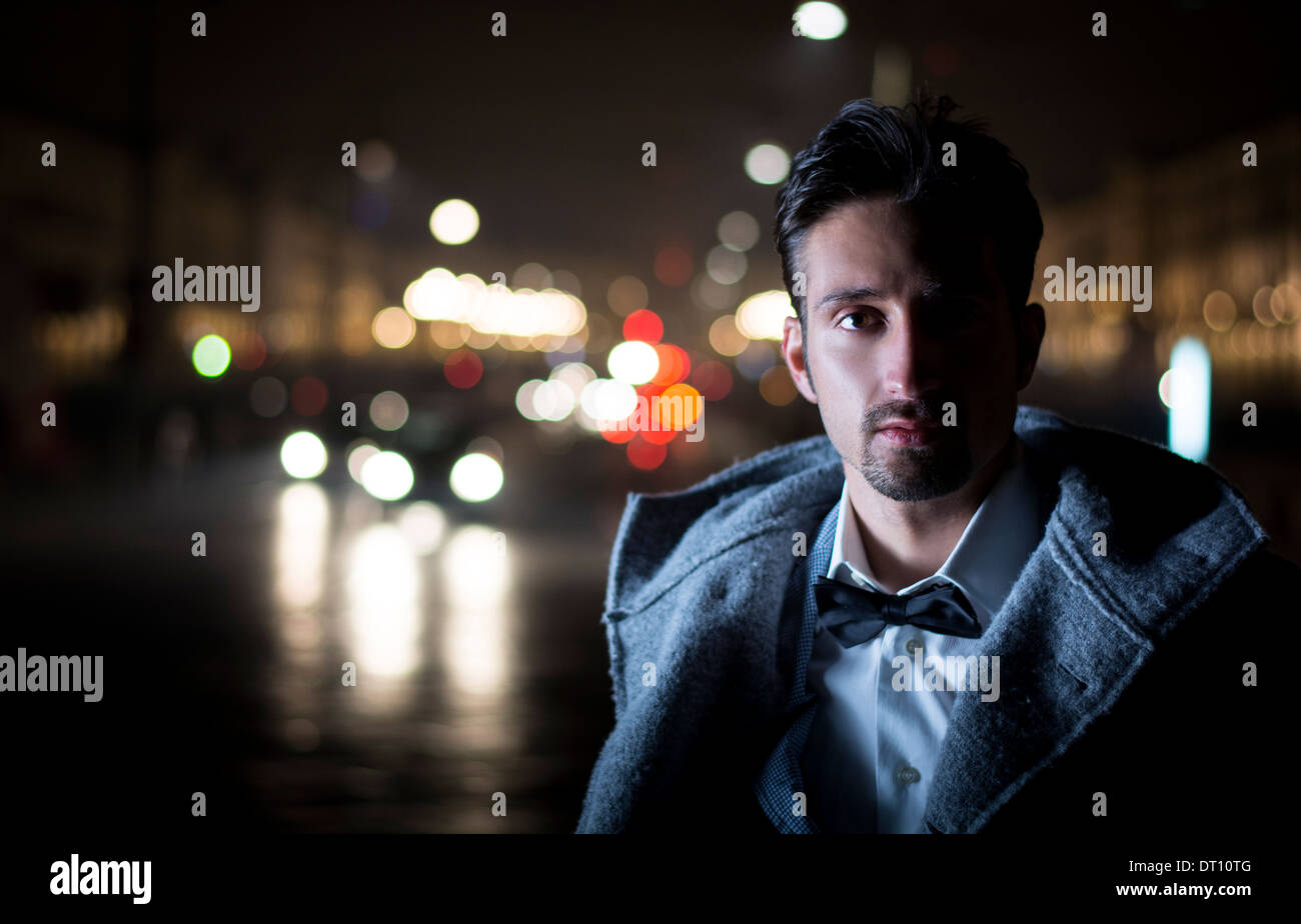 Attraktiven jungen Mann Porträt bei Nacht die Lichter der Stadt hinter ihm in Turin, Italien Stockfoto