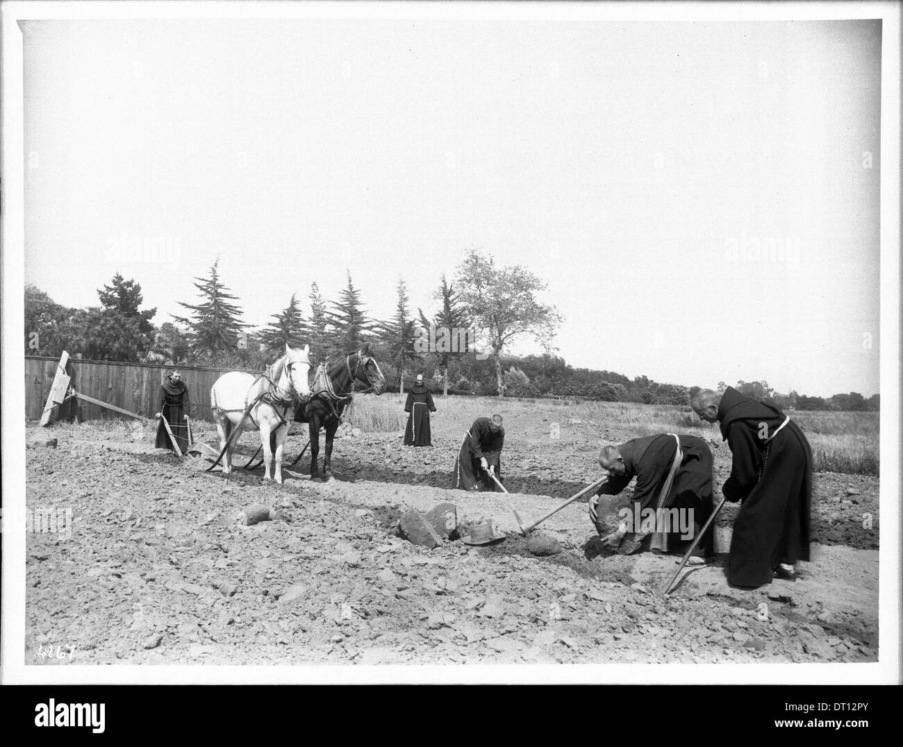 Foto von fünf Mönchen, die um 1901 auf dem steinigen Boden der Mission Santa Barbara arbeiten, die landwirtschaftliche Arbeit und religiöse Arbeit in der Mission zeigen. Stockfoto