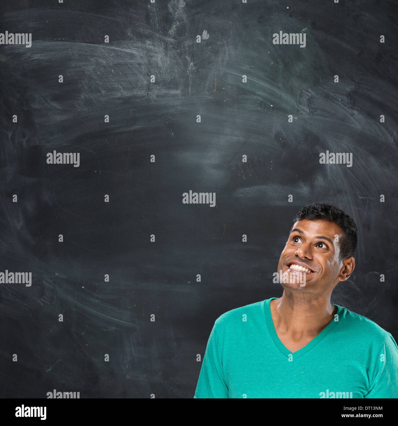 Porträt eines glücklichen asiatischen/indischen stehen neben einer Tafel. Stockfoto