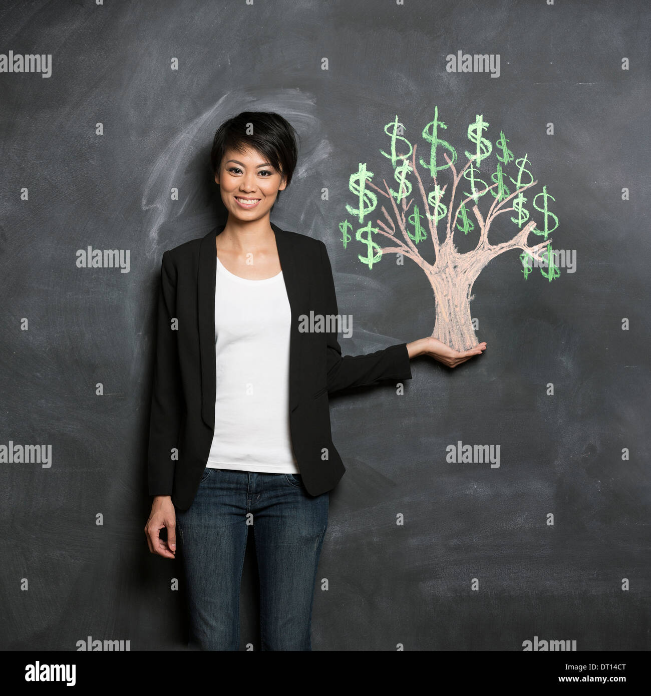 Glücklich asiatische Geschäftsfrau vor Kreide Geldbaum Zeichnung auf Tafel. Stockfoto