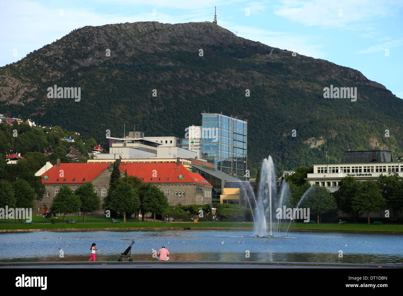 Mount Ulriken bildet einen Hintergrund, während ein Mann und ein Mädchen sind in Lille Lungegårdsvannet in Bergen, Norwegen, während ein Sommerabend. Stockfoto