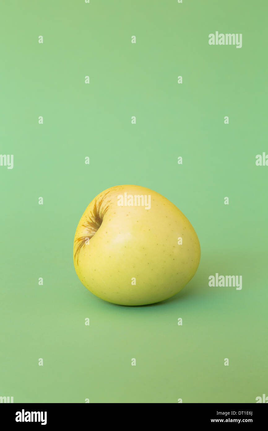 einzigen Golden Delicious Apfel auf grünem Hintergrund Stockfoto