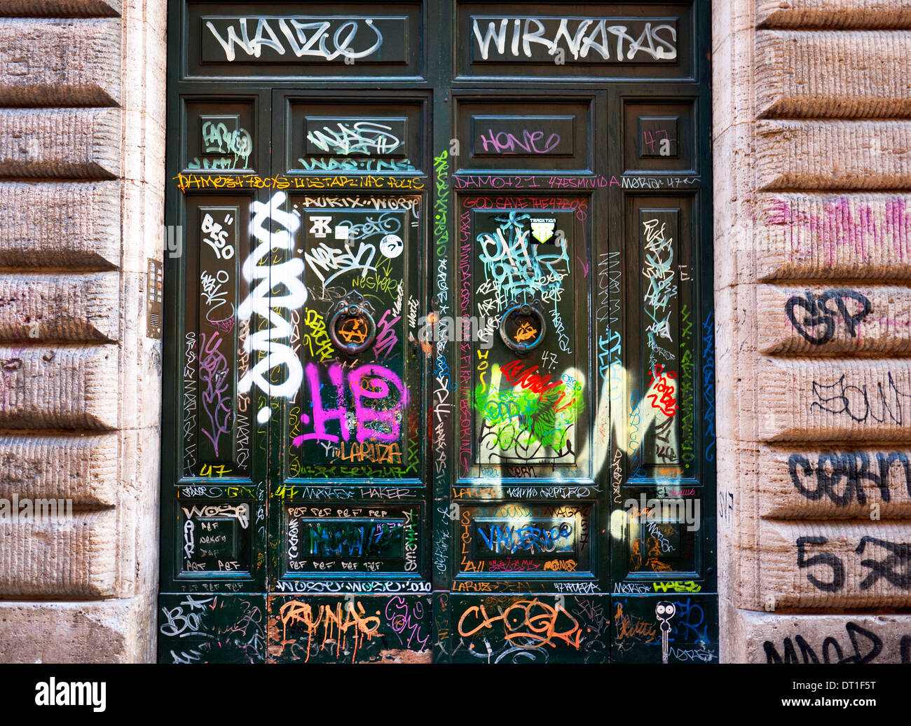 Graffiti gesprüht auf Türen in Trastevere, Rom, Italien. Stockfoto