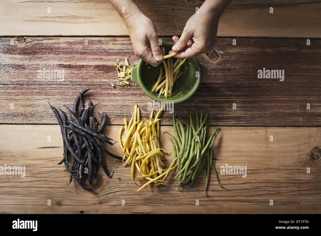 Bio grüne gelbe und schwarze Gartenbohnen Bohnen frisches Gemüse wird gekrönt und angebundene durch eine Person vor dem Kochen und Essen Stockfoto
