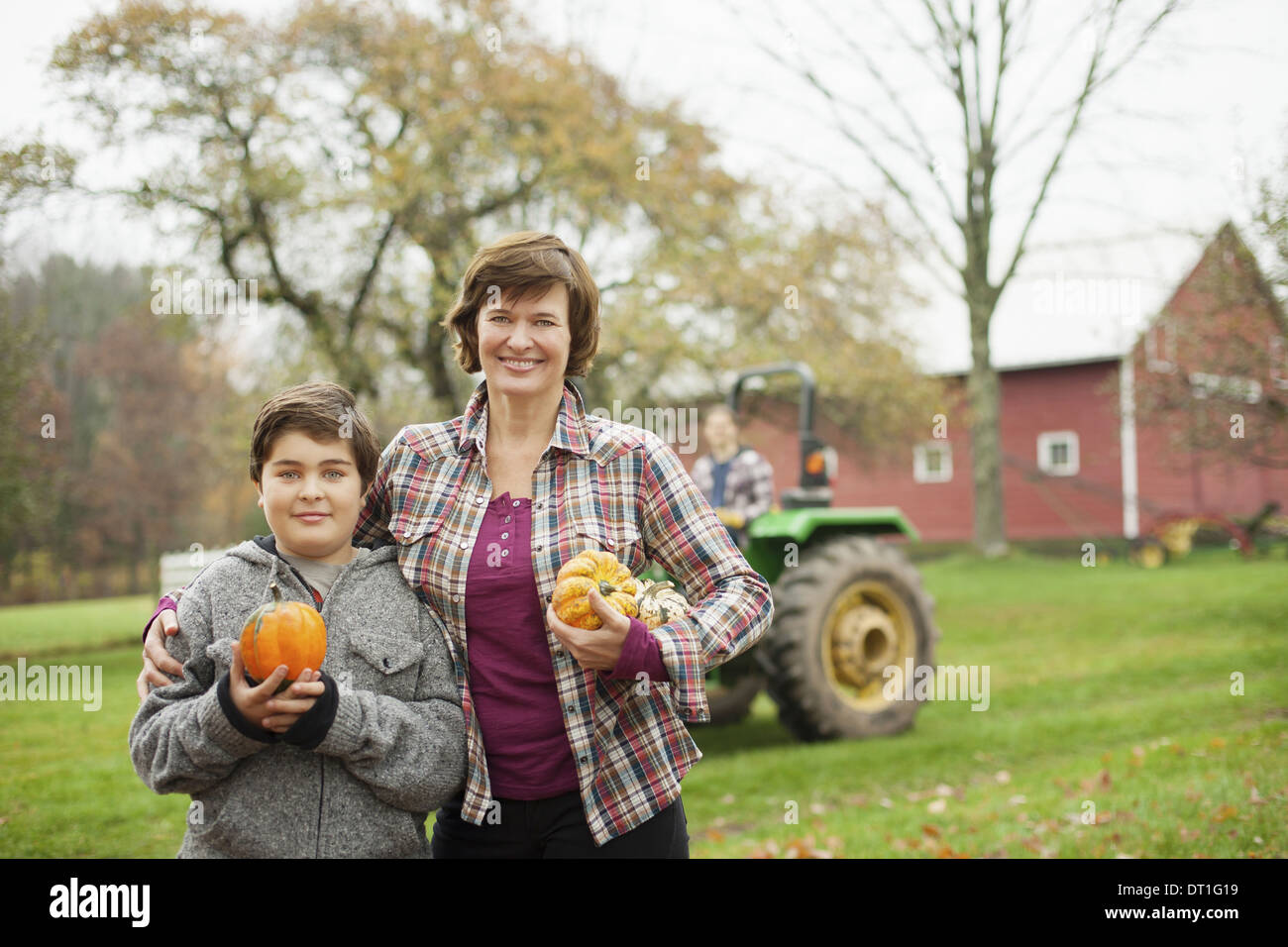 Zwei Menschen eine Frau und ein Kind auf einem Bio-Bauernhof mit Zucchini und Kürbisse Bio Gemüse geerntet Stockfoto