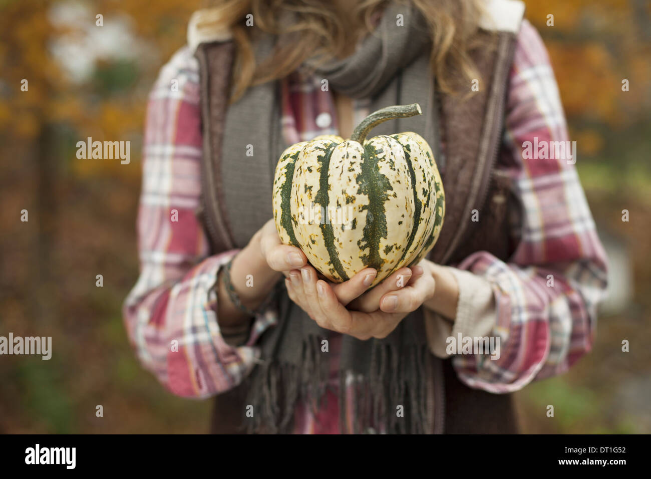 Bio Bauernhof Frau hält eine große gestreifte squash Gemüse Stockfoto