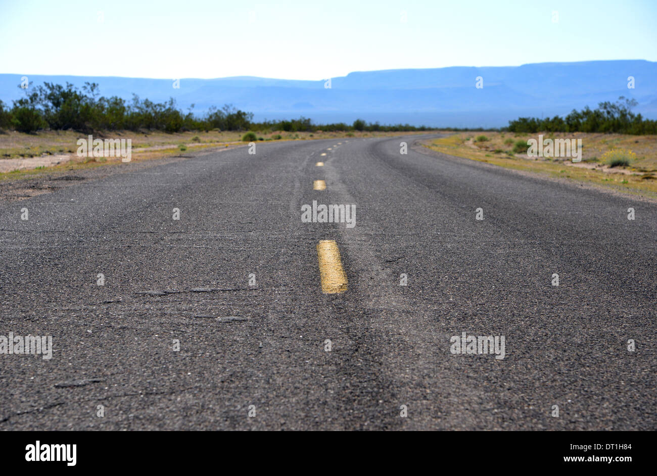 Route 66, Arizona, USA. Lange Straße Kurven Weg in die Ferne unter blauem Himmel einsam Stockfoto