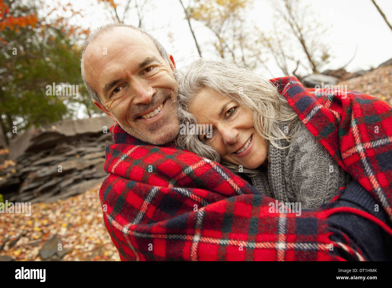 Ein paar Mann und Frau an einem Tag im Herbst teilen eine Picknickdecke, um warm zu halten Stockfoto