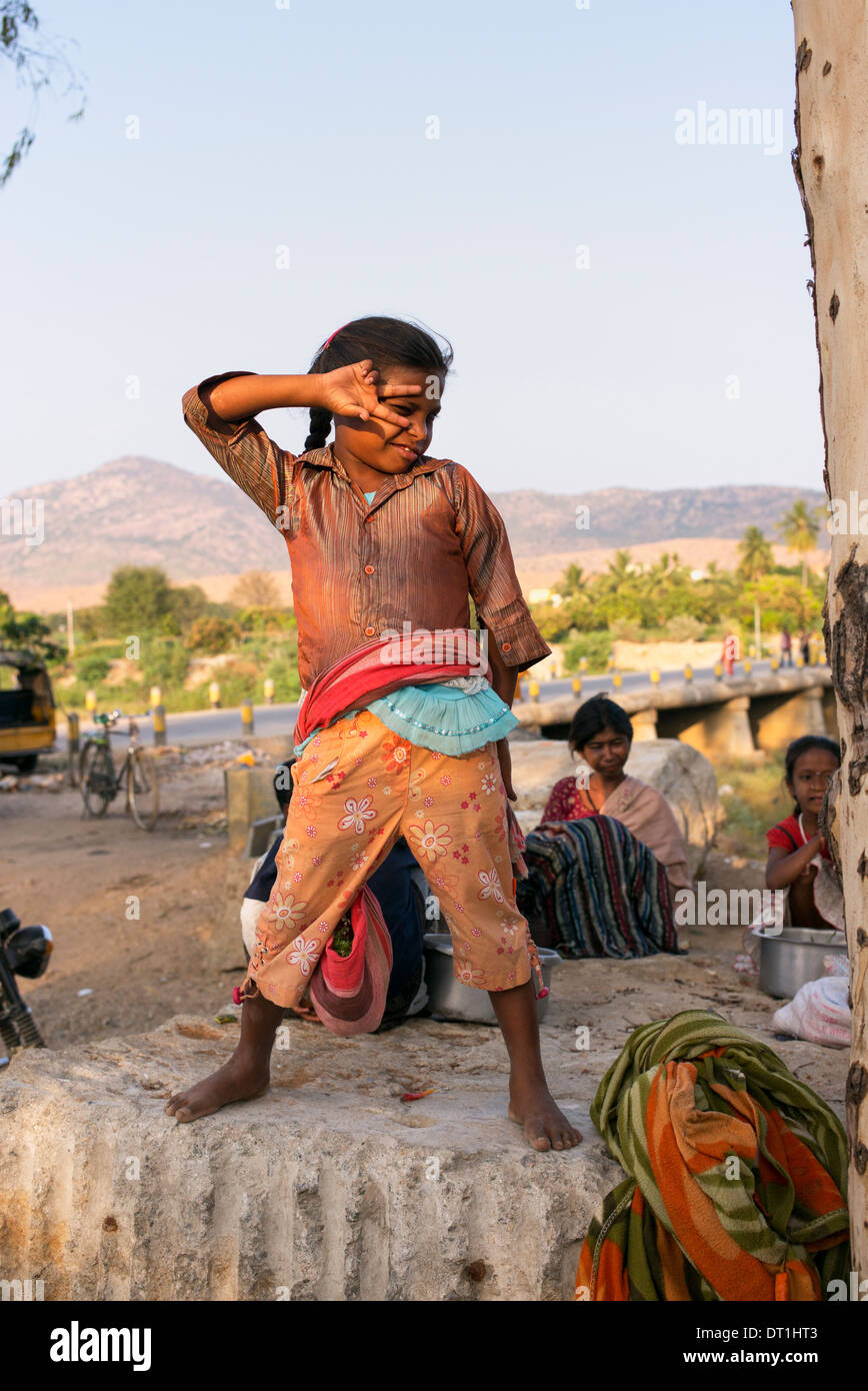 Glücklich Arm niedriger Kaste indische Mädchen auf einem Felsen posieren auf einem indischen Markt. Andhra Pradesh, Indien Stockfoto