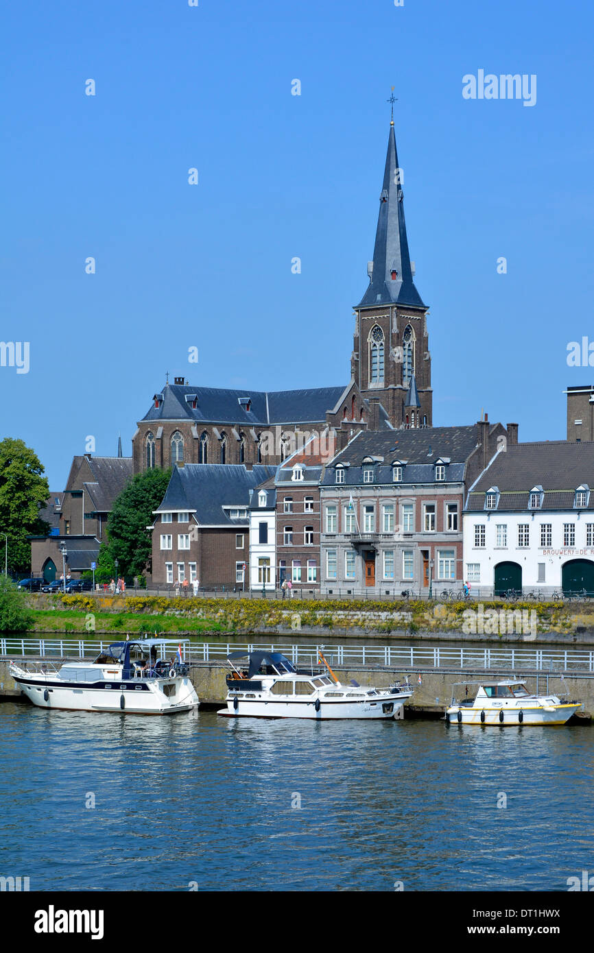 Maastricht River Maas (maas) und lange Kaimauer, die den Hauptwasserweg trennt, bieten Anlegeplätze für Motorboote Kirchturm Wahrzeichen EU Stockfoto