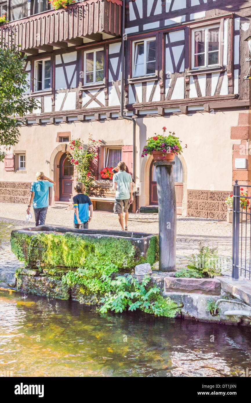 Touristen vor einem Fachwerkhaus am Ufer eines Baches in der Altstadt von Schiltach, Schwarzwald Stockfoto