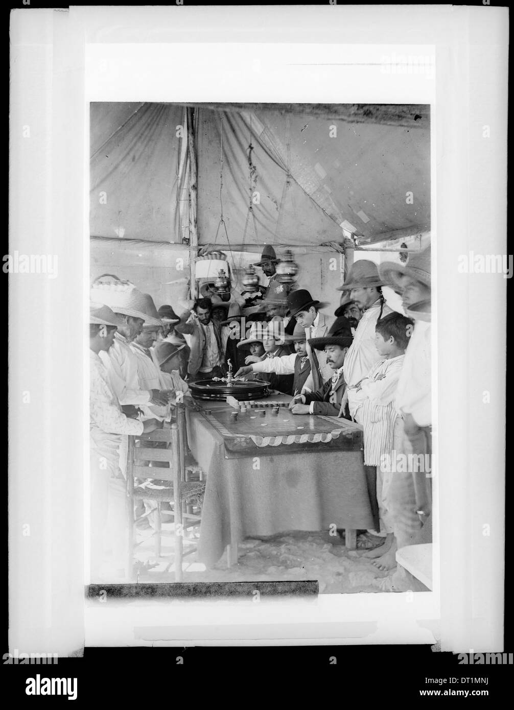 Ein Foto, das Spieler zeigt, die um 1905 in einem Zelt in Mexiko-Stadt Roulette spielen, und die Szene der Glücksspielkultur des frühen 20. Jahrhunderts erfasst. Stockfoto