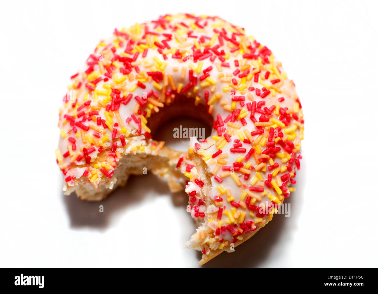 White iced Ring Donut mit Biss genommen, London Stockfoto
