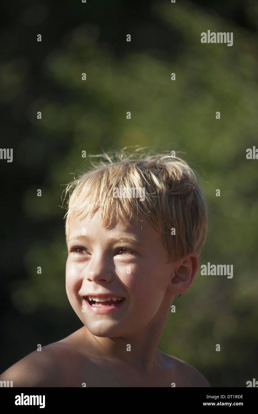 Ein Kind dreht seinen Kopf über seine Schulter lächelnd schauen Stockfoto