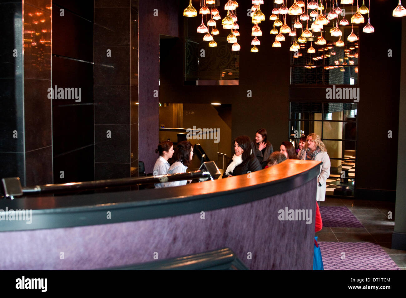 Dundee, Schottland, Vereinigtes Königreich. 6. Februar 2014. Die Malmaison ist ein Hotel im französischen Stil luxuriöse und exklusive formell das historische Tay Hotel und ist aufgeführt C Gebäude jetzt öffentlich zugänglich auf Donnerstag, 6. Februar 2014 in Dundee. Zwei weibliche Personal an der Rezeption eine Gruppe von Gästen im Bereich Hauptrezeption im Malmaison Hotel zu unterstützen. Bildnachweis: Dundee Photographics / Alamy Live News Stockfoto