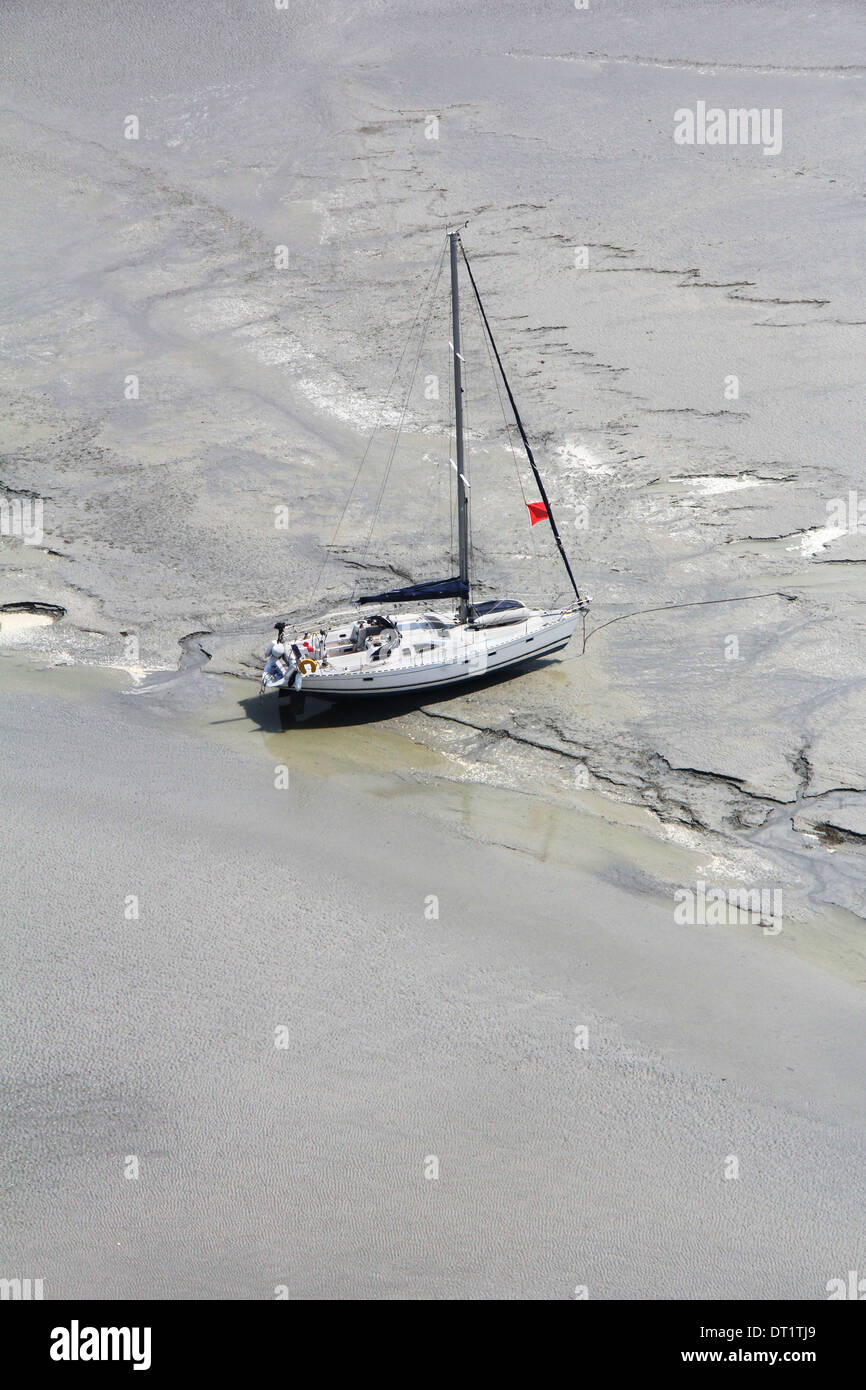 Gestrandete Boot in der Nähe der Abtei Mont Saint Michel wartet Flut, um Segel zu setzen. Normandie, Frankreich Stockfoto