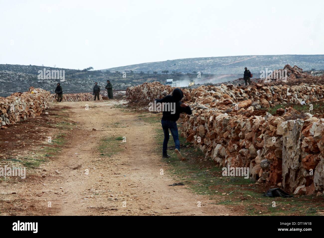 Nablus, Westjordanland, Palästinensische Gebiete. 6. Februar 2014. Eine palästinensische Jugend wirft Steinen auf israelische Sicherheitskräfte bei Zusammenstößen, die nach einer Auseinandersetzung zwischen Palästinensern und jüdischen Siedler in der Westbank Qusra, in der Nähe von Nablus, 6. Februar 2014. Zusammenstöße brach in der Nähe von Nablus am Donnerstag nach Siedler aus der nahe gelegenen Siedlung Esh Kodesh eine Gruppe von palästinensischen Bauern, sie zu stoppen, von der Ernte ihr Land im Dorf Qusra angegriffen, ein palästinensischer Beamter sagte Credit: Nedal Eshtayah/APA Images/ZUMAPRESS.com/Alamy Live News Stockfoto