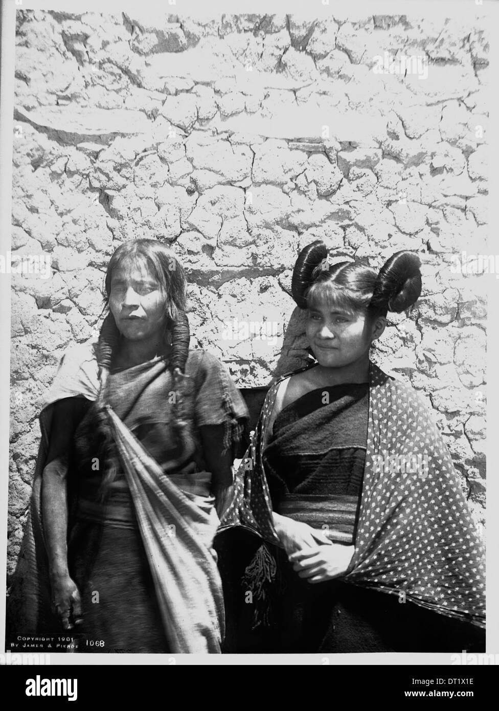 Eine Hopi-Indianerin und ihre Tochter werden im Dorf Oraibi in einer Nahaufnahme dargestellt, die um 1901 aufgenommen wurde und das kulturelle Leben der Hopi widerspiegelt. Stockfoto