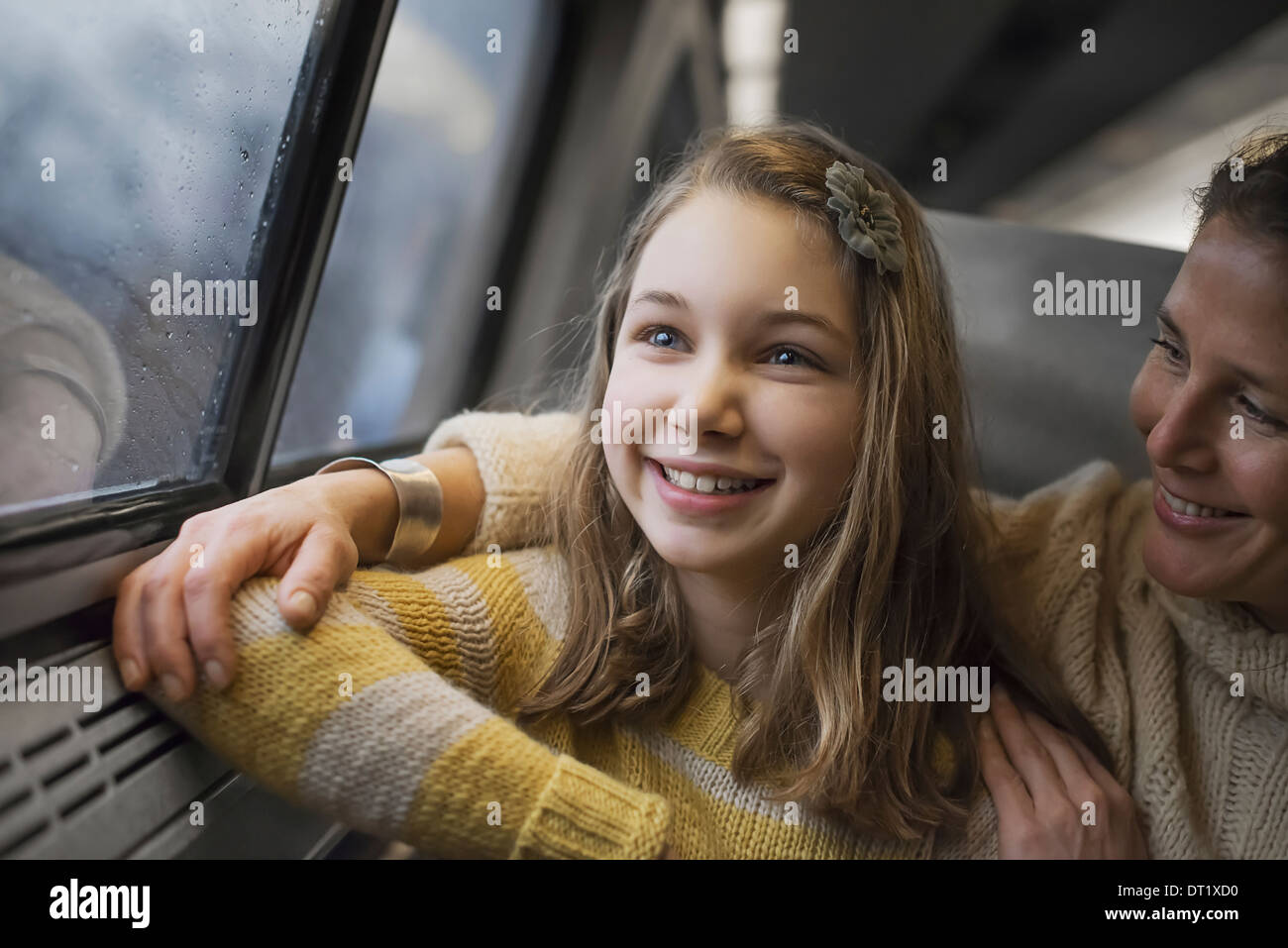 Ein Mann und ein junges Mädchen sitzt neben dem Fenster in einem Zug Wagen Sie den Blick auf die Landschaft lächelnd in Aufregung Stockfoto